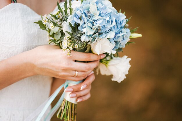 Foto lindo buquê de flores nas mãos da noiva. copie o espaço