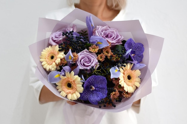 Lindo buquê de flores nas mãos de uma foto de mulher para cartão postal e catálogo de uma floricultura online entrega de flores frescas