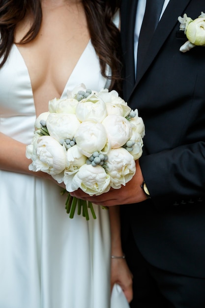 Lindo buquê de flores nas mãos dos noivos