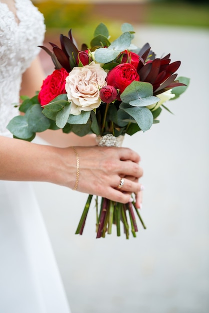 Foto lindo buquê de flores nas mãos dos noivos