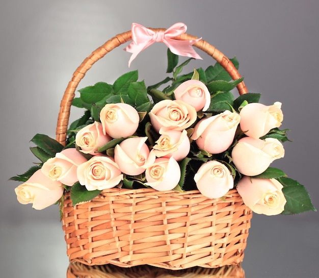 Lindo buquê de rosas na cesta em fundo cinza