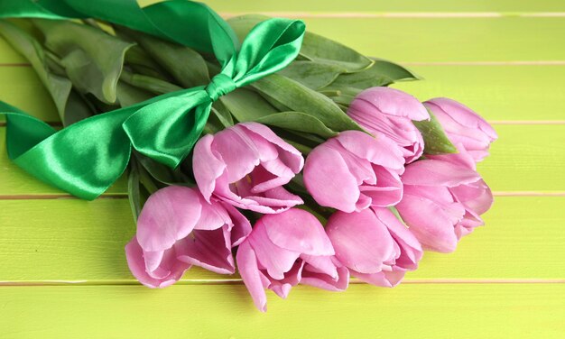 Lindo buquê de tulipas roxas em fundo verde de madeira