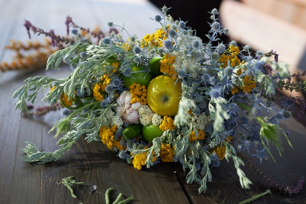 Lindo buquê perfumado de flores silvestres mentira sobre uma mesa de madeira, close-up