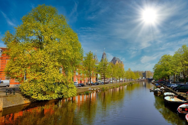 Lindo canal fluvial com barcos e árvores verdes em Amsterdã, Holanda, Holanda