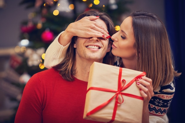 lindo casal adulto com presente sobre a árvore de Natal