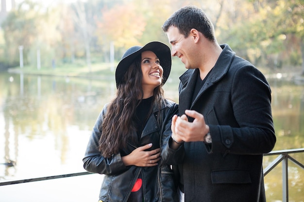 Lindo casal andando no parque outono perto de um lago