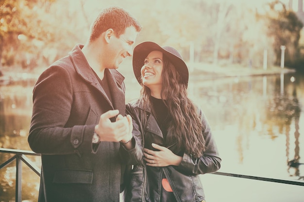 Lindo casal andando no parque outono perto de um lago