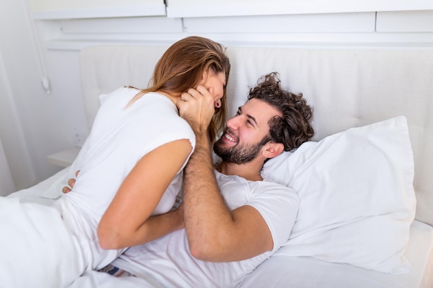 Lindo casal apaixonado beijando na cama. lindo casal jovem deitado juntos na cama.