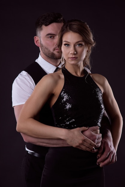 Lindo casal apaixonado em elegantes vestidos de noite em um terno abraço