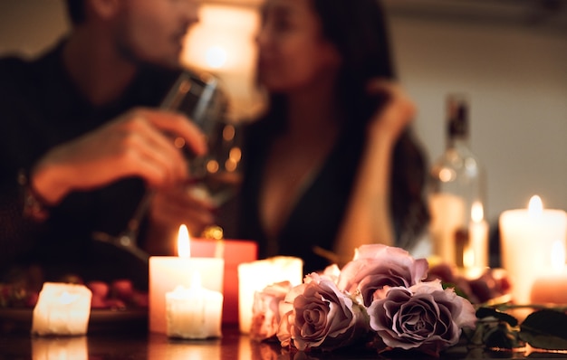 Foto lindo casal apaixonado jantando à luz de velas em casa, bebendo vinho, brindando