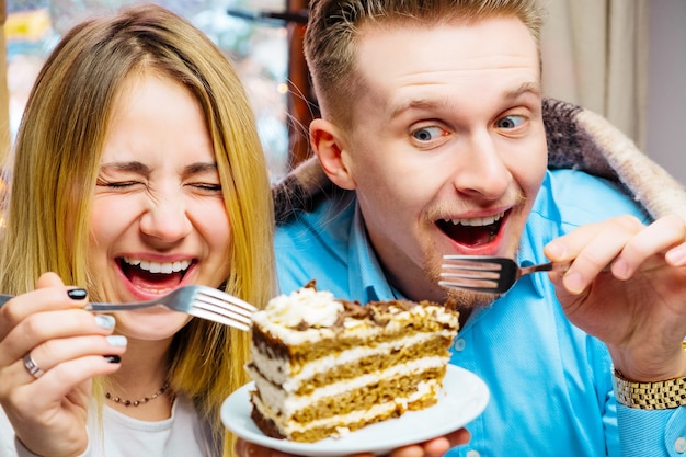 Foto lindo casal apaixonado namorando em um café de bolo