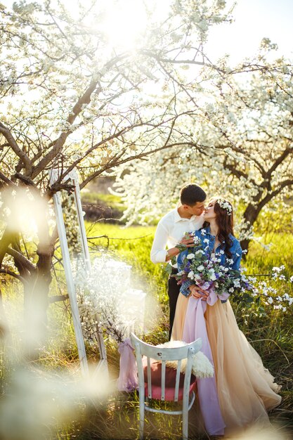 Lindo casal apaixonado nos jardins florescendo. conceito de casamento. grande luz do sol. adoráveis noivos