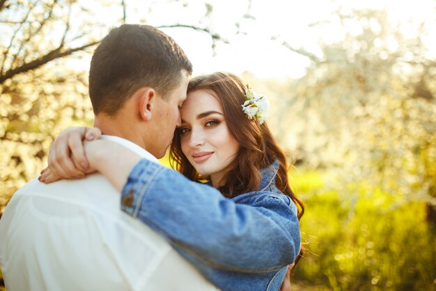 Lindo casal apaixonado nos jardins florescendo. conceito de casamento. grande luz do sol. adoráveis noivos