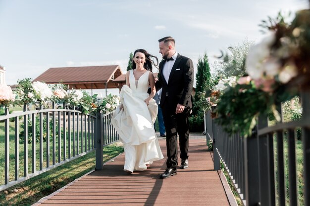 Lindo casal atravessando a ponte no parque. feriados e eventos