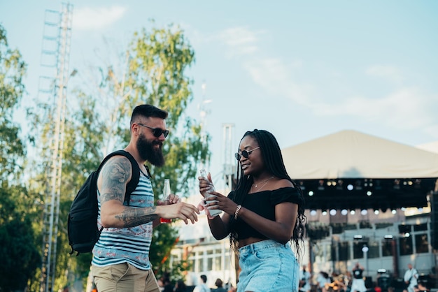 Lindo casal bebendo coquetéis e se divertindo no festival de música