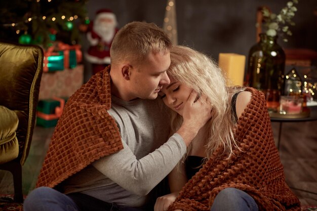 Lindo casal de esposa e marido no interior da casa estética aconchegante com árvore de Natal festiva Momento verdadeiro sincero Bom humor e se divertindo juntos História de amor de Natal