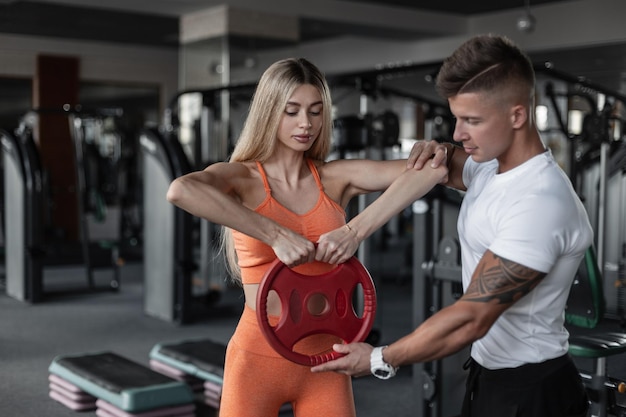 Lindo casal de fitness atlético malhando na academia