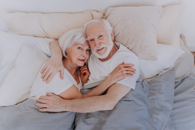 Lindo casal de idosos curtindo o tempo juntos em casa - momentos românticos em casa, casal de idosos na cama em casa