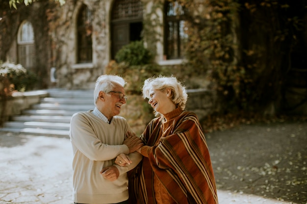 Lindo casal de idosos se abraçando no parque outono
