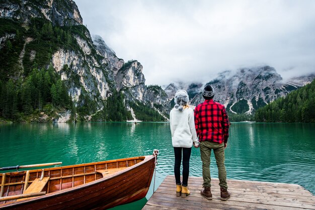 Lindo casal de jovens visitando um lago alpino em Braies Itália