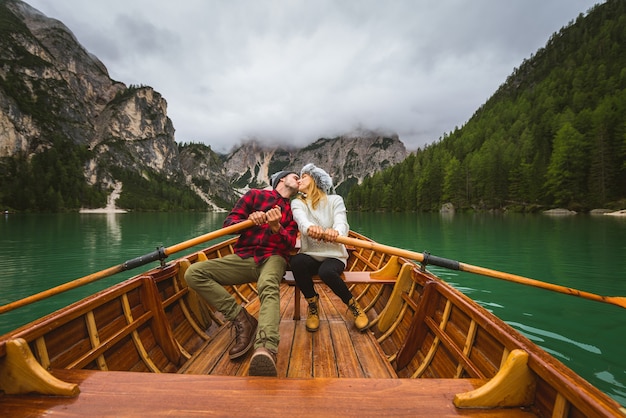 Lindo casal de jovens visitando um lago alpino em Braies Itália