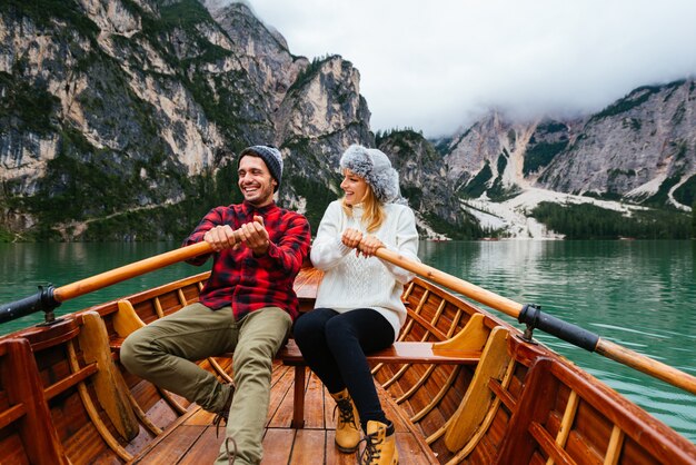 Lindo casal de jovens visitando um lago alpino em Braies Itália