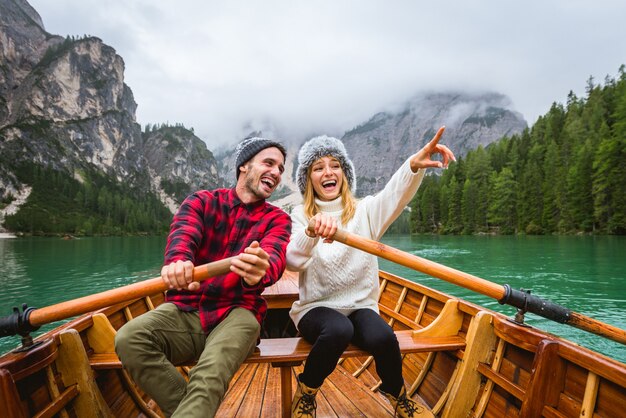 Lindo casal de jovens visitando um lago alpino em Braies Itália