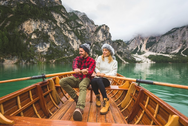 Lindo casal de jovens visitando um lago alpino em braies itália