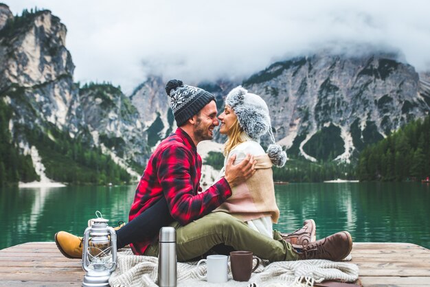 Lindo casal de jovens visitando um lago alpino em Braies Itália