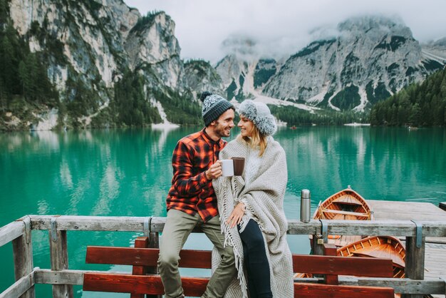 Lindo casal de jovens visitando um lago alpino em braies itália