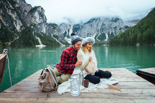 Lindo casal de jovens visitando um lago alpino em Braies Itália