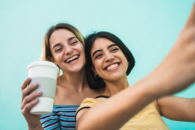 Lindo casal de lésbicas tomando uma selfie com telefone.