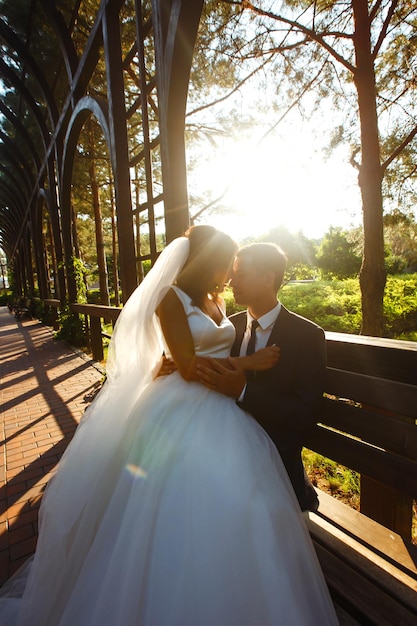 Lindo casal de noivos ao pôr do sol Noiva noivo em traje de casamento com buquê de flores Romântico