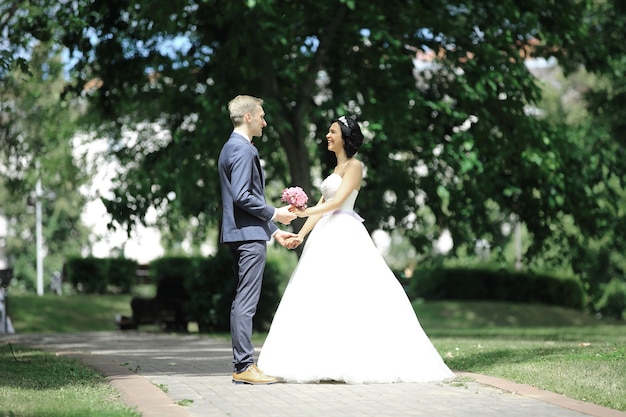 Lindo casal de noivos caminhando no casamento ao ar livre