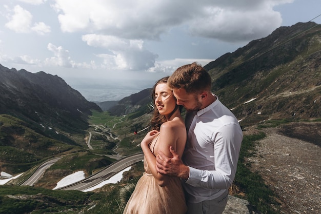 Lindo casal de noivos noivos apaixonados no fundo das montanhas