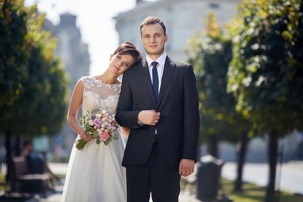 Lindo casal de noivos posando na cidade velha.