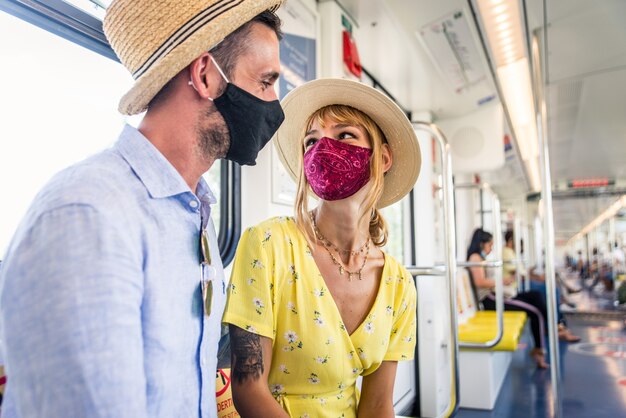 Lindo casal dirigindo um vagão de metrô durante a pandemia covid-19