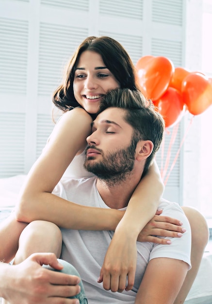 Lindo casal elegante apaixonado está se abraçando e aproveitando o tempo que passamos juntos no quarto em casa. conceito de amor e dia de são valentim. relacionamentos e família