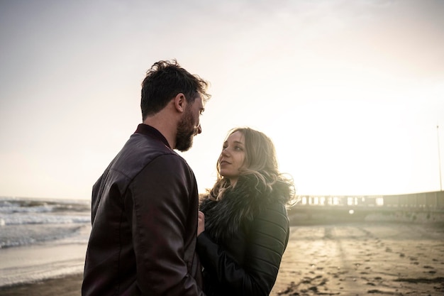 Lindo casal em relacionamento abraçando e amando um ao outro no primeiro namoro Menina e menino curtindo a atividade de lazer ao ar livre na praia romântica na temporada de outono Relacionamento de casal