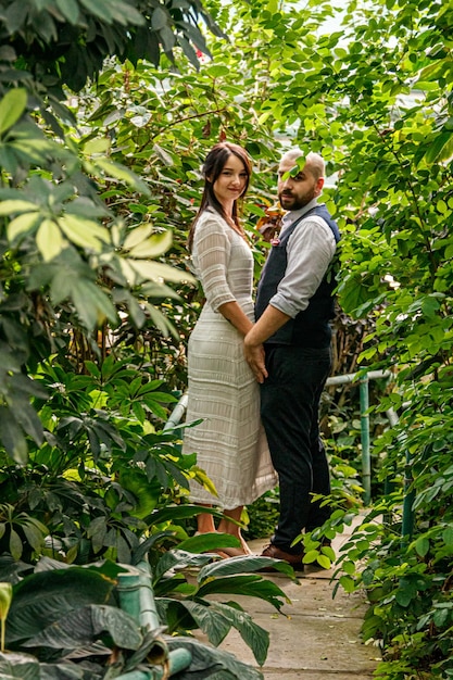 Lindo casal garota e cara no parque entre árvores tropicais