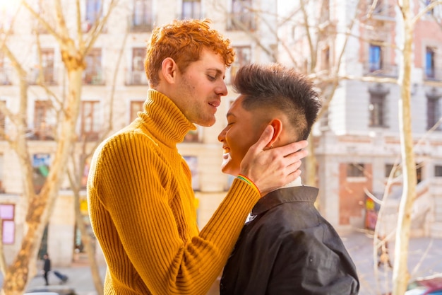 Lindo casal gay sendo romântico em casa na varanda do sofá se beijando na testa conceito lgbt