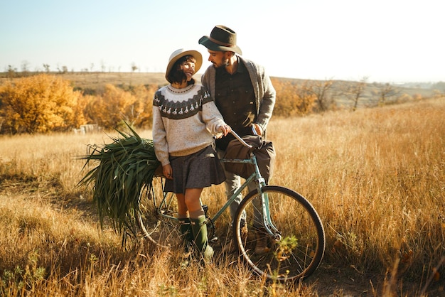 Lindo casal hipster com bicicleta Casal vestindo lindos chapéus e blusas Estilo de vida