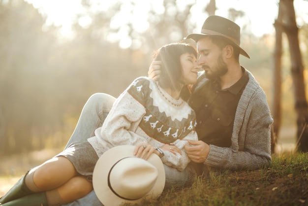 Lindo casal hipster olhando um para o outro Casal usando lindos chapéus e suéteres