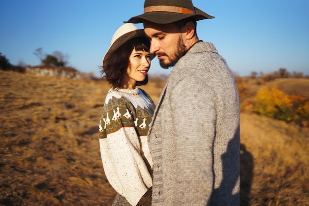 Lindo casal hipster olhando um para o outro Casal usando lindos chapéus e suéteres