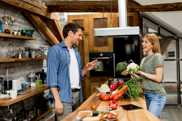 Lindo casal jovem alegre cozinhar jantar juntos