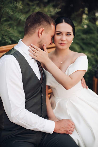 Lindo casal jovem apaixonado posa para o álbum de casamento no parque de verão juntos