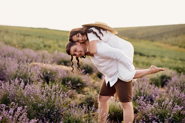 Lindo casal jovem caminhando em um campo de lavanda