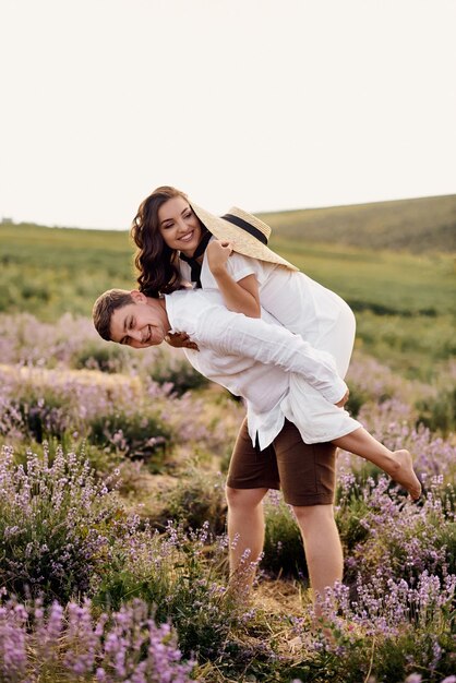 Lindo casal jovem caminhando em um campo de lavanda