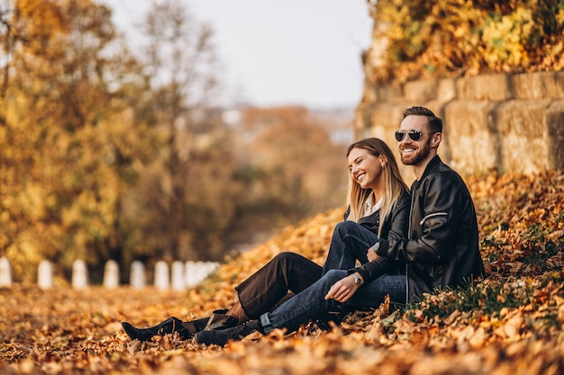 Lindo casal jovem caminhando no parque de outono em um dia ensolarado