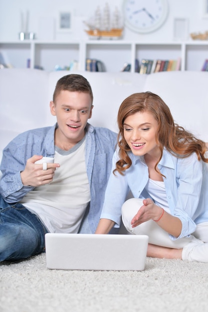 Lindo casal jovem com um laptop